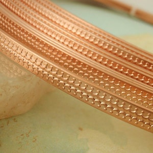 May include: Close-up of copper trim with a decorative scalloped pattern. The trim is shown in multiple layers, highlighting the intricate design.