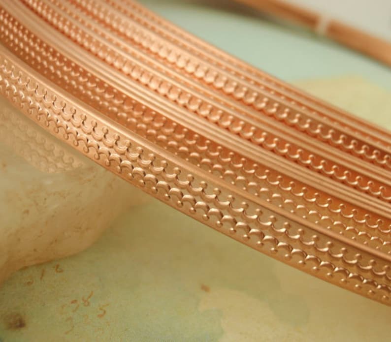 May include: Close-up of copper trim with a decorative scalloped pattern. The trim is shown in multiple layers, highlighting the intricate design.