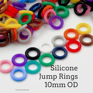 May include: A selection of brightly coloured silicone jump rings, 10mm OD, in shades such as pink, purple, green, blue, orange, and brown. The image includes the text "Silicone Jump Rings 10mm OD".