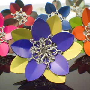 May include: A collection of colorful metal flowers with intricate designs. The flowers are made of metal and have a variety of colors, including pink, blue, yellow, orange, and green.