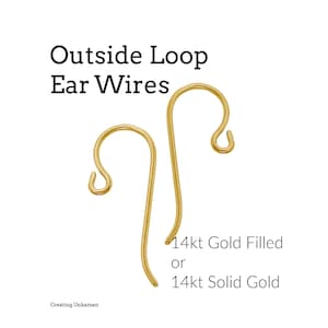 May include: Two gold-colored metal ear wires with an outside loop design. The text reads: Outside Loop Ear Wires, 14kt Gold Filled or 14kt Solid Gold, and Creating Unkamen. The ear wires have a curved hook shape with a small loop at the bottom.