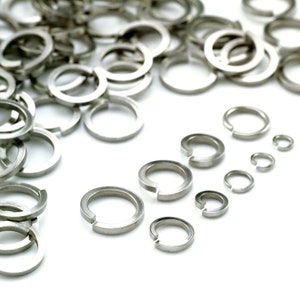 Puede incluir: Una variedad de anillos de retenci&oacute;n de metal de color plateado de diferentes tama&ntilde;os. Los anillos est&aacute;n dispuestos en una l&iacute;nea del m&aacute;s grande al m&aacute;s peque&ntilde;o.