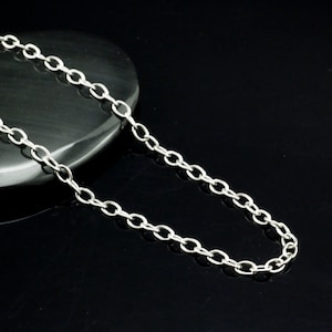 May include: A silver chain necklace with a delicate, oval-shaped link design.