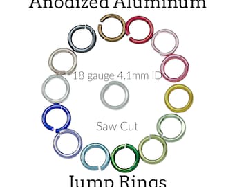 May include: An assortment of anodized aluminum jump rings arranged in a circle with one in the center. The rings are 18 gauge with a 4.1mm inner diameter and feature a saw cut. Text reads: Anodized Aluminum, 18 gauge 4.1mm ID, Saw Cut, Jump Rings.