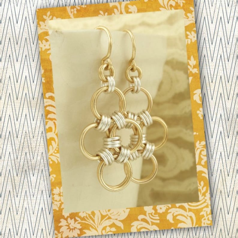 May include: Gold and silver chain earrings with a flower design. The earrings are made of interlocking circles.