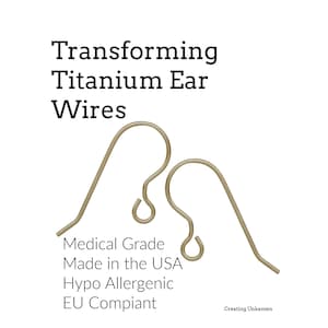 May include: Two curved titanium ear wires with a metallic finish. The text reads: Transforming Titanium Ear Wires, Medical Grade, Made in the USA, Hypo Allergenic, EU Compiant, and Creating Unkamen. These components are for jewelry making.