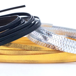 May include: Three rolls of decorative trim, one black, one gold, and one silver. The silver trim has a diamond pattern.