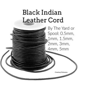 May include: A spool of black Indian leather cord with text reading Black Indian Leather Cord, By The Yard or Spool: 0.5mm, 1mm, 1.5mm, 2mm, 3mm, 4mm, 5mm, and Creating Unkamen. The cord is wrapped around a white cylindrical spool.