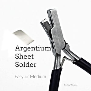 May include: A close-up of silver metal pliers with black handles, designed for sheet solder. The text "Argentium Sheet Solder" and "Easy or Medium" is visible on a white background.