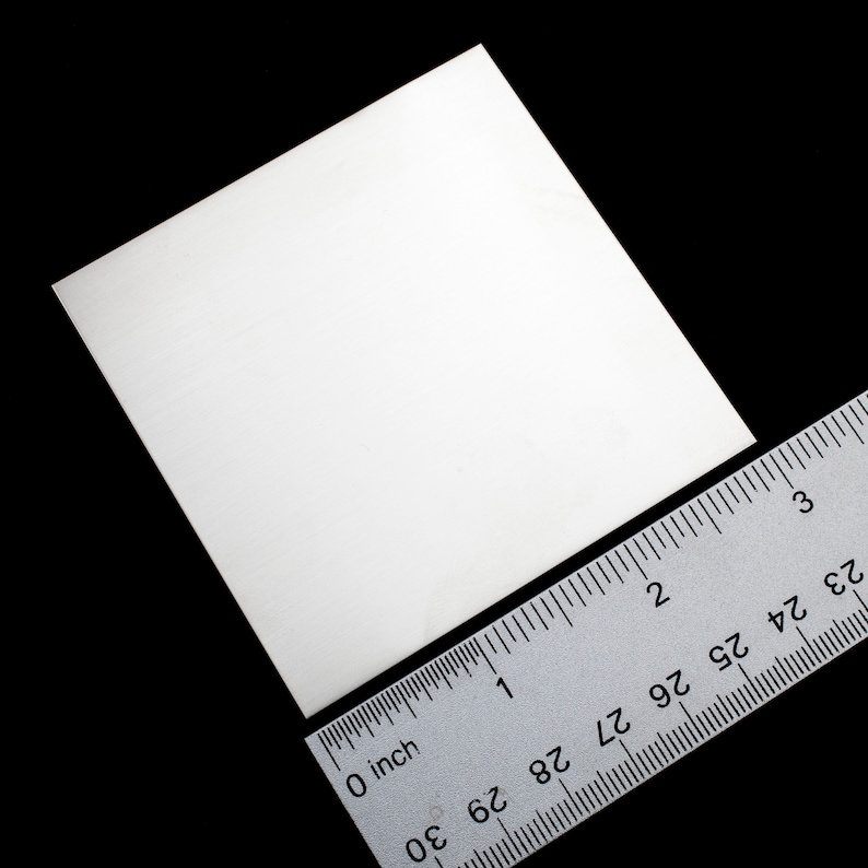 Op de afbeelding: Een wit vierkant stuk papier dat ongeveer 5 cm bij 5 cm meet, met een liniaal ernaast voor schaal.