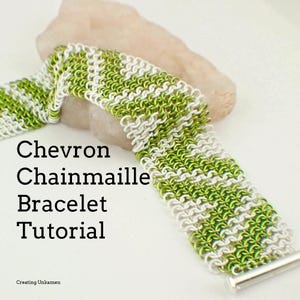 Pode incluir: Um bracelete de malha de chevron verde e branco com um fecho prateado. O bracelete é feito com pequenos anéis de metal e é um estilo de joalheria popular.  Tutorial de bracelete de malha de chevron.