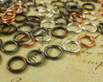 Könnte beinhalten: Sortiment an Sprungringen in verschiedenen Größen und Ausführungen, darunter Silber, Gold und Kupfer.