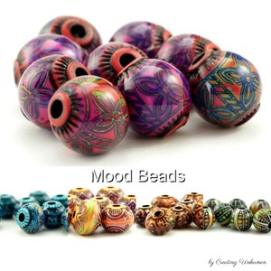 May include: Assortment of colorful mood beads with intricate patterns. The beads are made of wood and have a variety of colors, including red, blue, green, and yellow. The beads are arranged in a group, and the text "Mood Beads" is written below the group of beads.