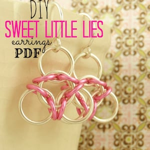 May include: DIY Sweet Little Lies earrings PDF. A pair of silver earrings with pink chain links.