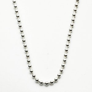 May include: A silver ball chain necklace. The chain is made of small, round beads.