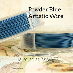 May include: Two spools of powder blue artistic wire are displayed. The text "Powder Blue Artistic Wire" is visible. The wire gauges are 18, 20, 22, 24, and 26. The spools are in clear plastic containers.