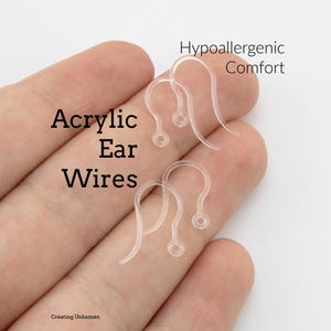 May include: Four clear acrylic ear wires with a curved hook shape and a small circular loop at the base for attaching jewelry components. The text Acrylic Ear Wires and Hypoallergenic Comfort is visible on the image along with Creating Unkamen.
