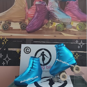 Puede incluir: Un conjunto de cubiertas para patines de colores brillantes en azul, plata, oro y morado. Las cubiertas est&aacute;n hechas de un material brillante y met&aacute;lico y tienen el texto "skatingbling.com" impreso en ellas. Las cubiertas se muestran sobre una superficie de madera con un fondo blanco.