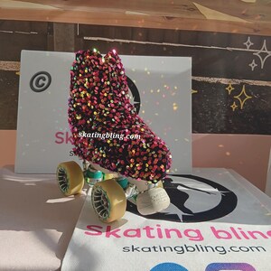 May include: A pair of roller skates with a black and pink sequined boot. The boot has a gold and green wheel and a black and white logo that says "skating bling".