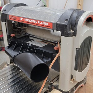 Ridgid 13" Thickness Planer with 4" dust extraction chute attached. Allows for dust collection in your woodworking shop.