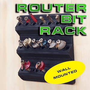May include: A black wall-mounted router bit rack with multiple rows of slots to hold router bits. The rack is labeled "WALL MOUNTED" in yellow.