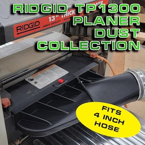 May include: A black dust collection system for a RIDGID TP1300 planer. The system has a 4-inch hose connection and a red button.