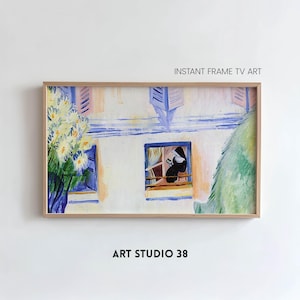 May include: Framed artwork depicting a building with blue shutters and a window. A person in a black habit is seated in the window. The artwork includes the text "INSTANT FRAME TV ART" and "ART STUDIO 38".