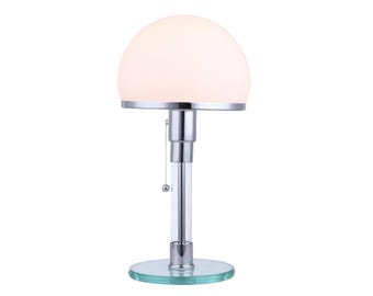 May include: A table lamp featuring a white frosted glass dome shade, a polished chrome metal frame, and a clear glass cylindrical stem. The lamp includes a circular glass base and a small pull chain switch hanging from the chrome socket housing.