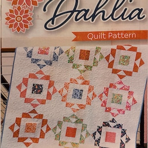 May include: A quilt pattern titled "Dahlia" with a finished size of 52.5" x 52.5". The quilt features a repeating block design in orange, blue, green, and pink on a white background. The text "Quilt Pattern" is visible.