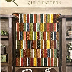 May include: A quilt pattern titled "Thick & Thin" with a colorful patchwork design. The quilt features vertical stripes in various patterns and colors. The finished size is 39" x 42 1/2".