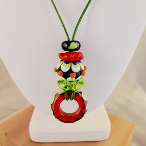 Orange, green and black artisan made glass bead necklace on leather cord