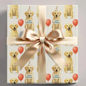 May include: A wrapped gift with a cream-colored background featuring a repeating pattern of yellow Labrador Retrievers, red balloons, and the text "Happy Birthday." The gift is tied with a satin ribbon and bow.