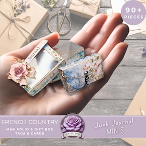 May include: A miniature journal and gift box set with a French country theme. The journal is open, revealing a blank interior, and the gift box is closed with a button clasp. The set is decorated with floral patterns and lace trim. The image also includes the text "90+ PIECES".