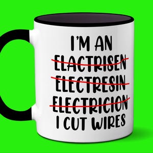 May include: White ceramic mug with a black handle and rim. The mug features the text "I'M AN ELECTRISEN ELECTRESIN ELECTRICION I CUT WIRES" in black, with the incorrect words crossed out in red. The background is bright green.