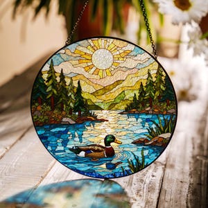 a stained glass picture of ducks swimming in a lake