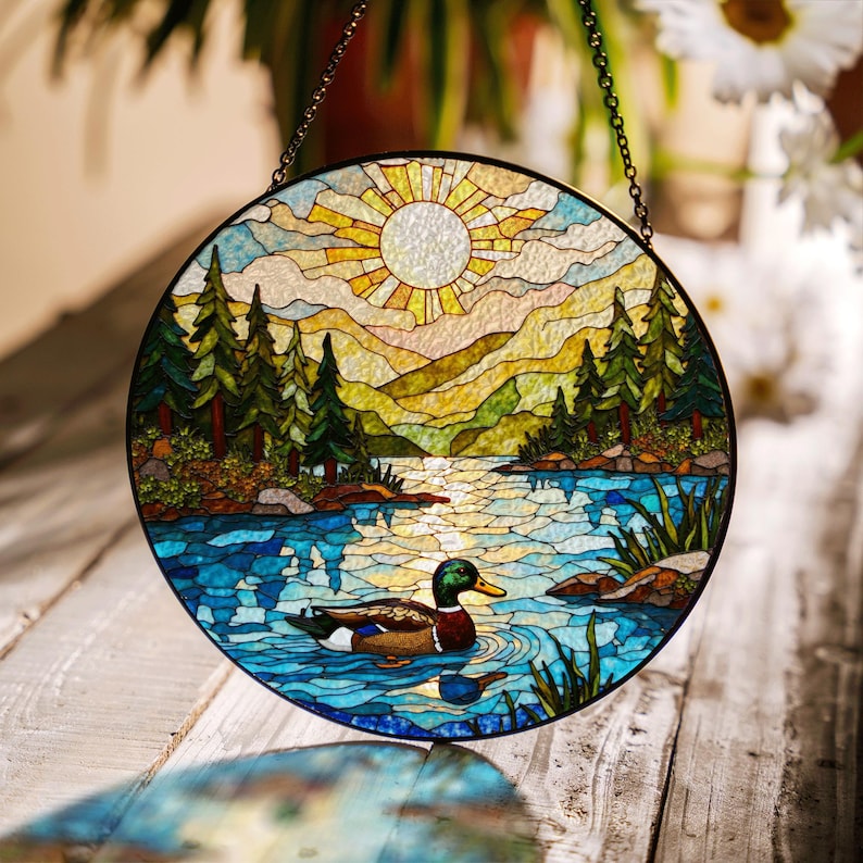 a stained glass picture of ducks swimming in a lake