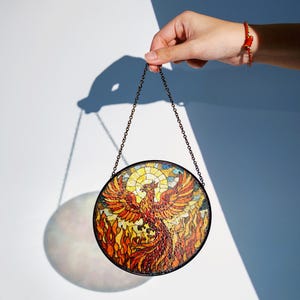 a hand holding a stained glass bird ornament