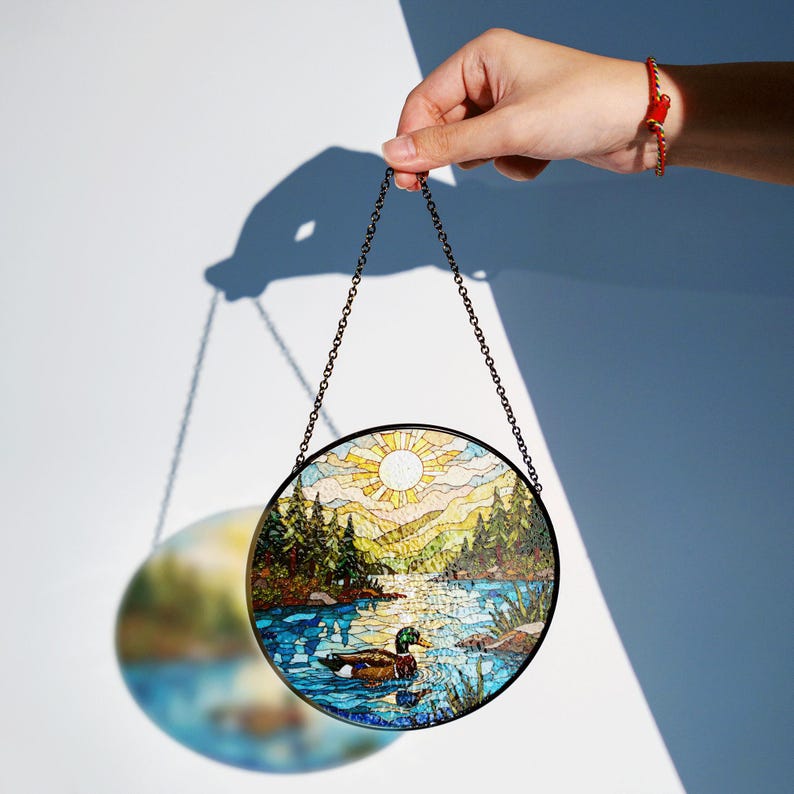 a hand holding a stained glass sun catcher