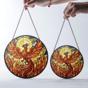 a hand holding a pair of stained glass plates