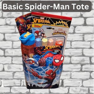 May include: A Spider-Man themed tote bag filled with toys and accessories. The tote features a blue and white design with Spider-Man graphics. Contents include a water bottle, Spidey Amazing Friends toys, and other Spider-Man themed items. The text "Basic Spider-Man Tote" is at the top.