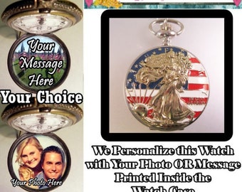 May include: A silver pocket watch with a design of the Statue of Liberty on a red, white, and blue American flag background. The watch can be personalized with a photo or message printed inside the case. "Bright Eyes Treasures" is written on a banner above the watch.
