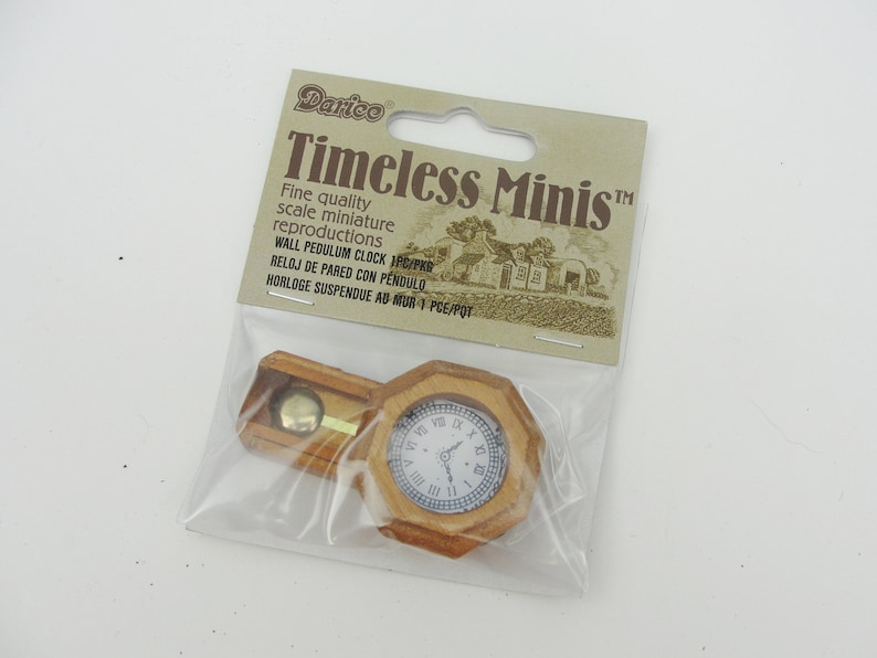 May include: A miniature wooden wall clock with a pendulum, packaged in a clear plastic bag. The packaging features the text "Timeless Minis" and "Darico".