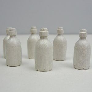 Puede incluir: Seis botellas de cer&aacute;mica blanca con una superficie texturizada. Las botellas son todas del mismo tama&ntilde;o y forma.