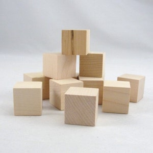 May include: A group of ten unfinished wooden cubes stacked in a pyramid shape. The cubes are made of natural wood and have a smooth, unpainted surface.