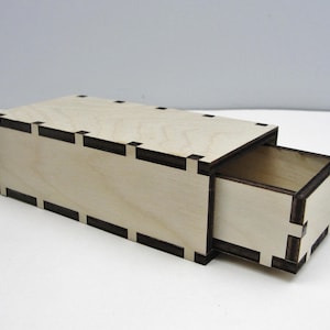 May include: A wooden box with a drawer that slides out. The box is made of light wood with a dark brown trim. The drawer is also made of light wood with a dark brown trim.