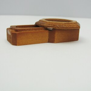 May include: A wooden box with a hinged lid. The box is made of light brown wood and has a simple design.
