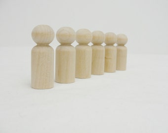 May include: A row of seven wooden peg dolls, all the same size and shape, standing in a line on a white surface.