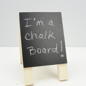 May include: A small black chalkboard easel with the words "I'm a chalk board!" written in white chalk.
