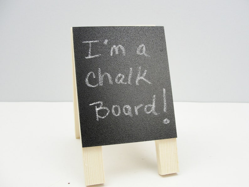 May include: A small black chalkboard easel with the words "I'm a chalk board!" written in white chalk.