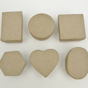 May include: Six cardboard boxes in different shapes: a rectangle, a circle, a heart, a hexagon, a square, and an oval. The boxes are all made of brown cardboard and have a rough texture.
